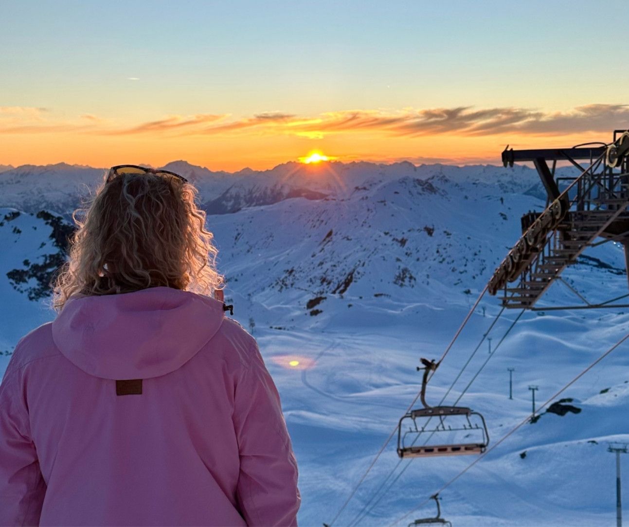 Woman looking at a sunset on the mountain in La Plagne ski resort